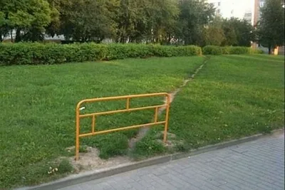 'barrière posée devant un chemin naturellement creusé à travers une pelouse'